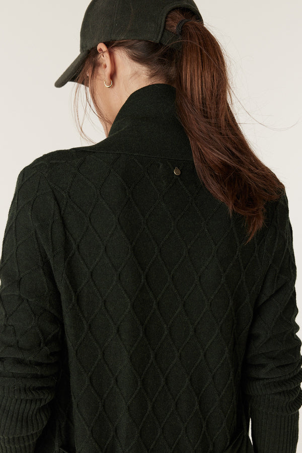 Woman from behind wearing a moss green merino wool cardigan with diamond cable stitching and a Milano collar.