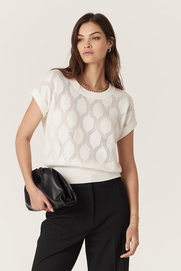 Model wears a white Silk Tencel Wave Knit Top with pointelle jersey stitch, crew neck, and rib trims.