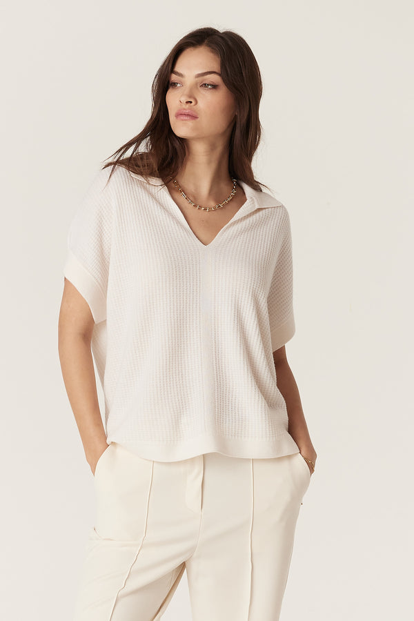 Woman wearing a relaxed fit milk-colored Cashwool waffle knit top with a V-neck collar and short sleeves.