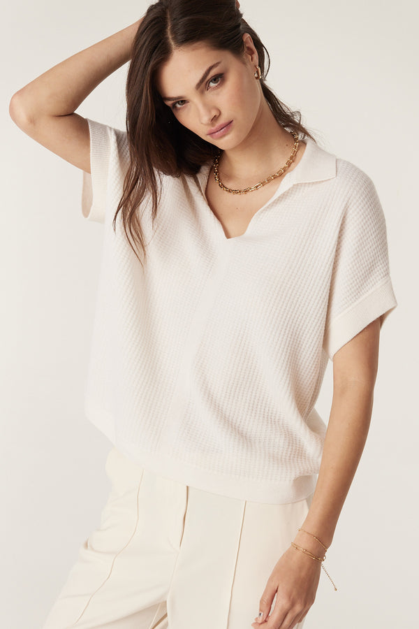 Woman wearing a relaxed fit milk-colored Cashwool waffle knit top with a V-neck collar and gold chain.
