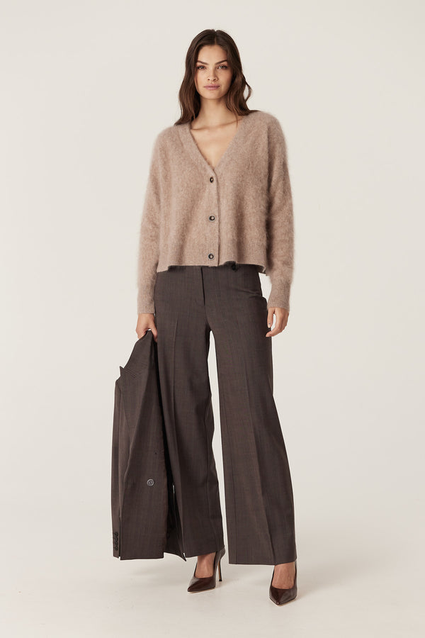 Woman in a relaxed fit mink brushed cashwool V-neck cardigan with button front, holding a matching jacket.