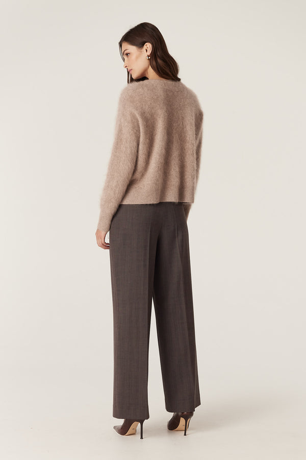 Model wearing a mink brushed cashwool V-neck cardigan with a soft, textured finish and dark trousers.