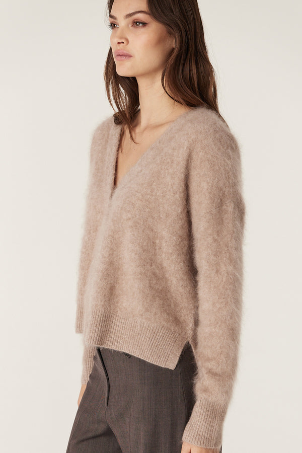 Woman wearing a relaxed-fit mink brushed cashwool V-neck cardigan with ribbed cuffs and hem.
