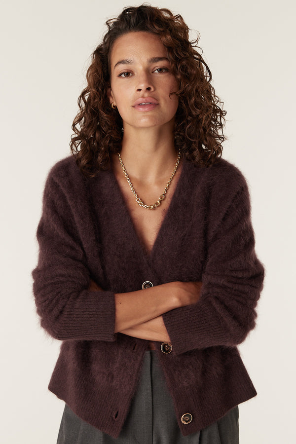 Woman in a shiraz brushed cashwool V-neck cardigan with a gold chain necklace.