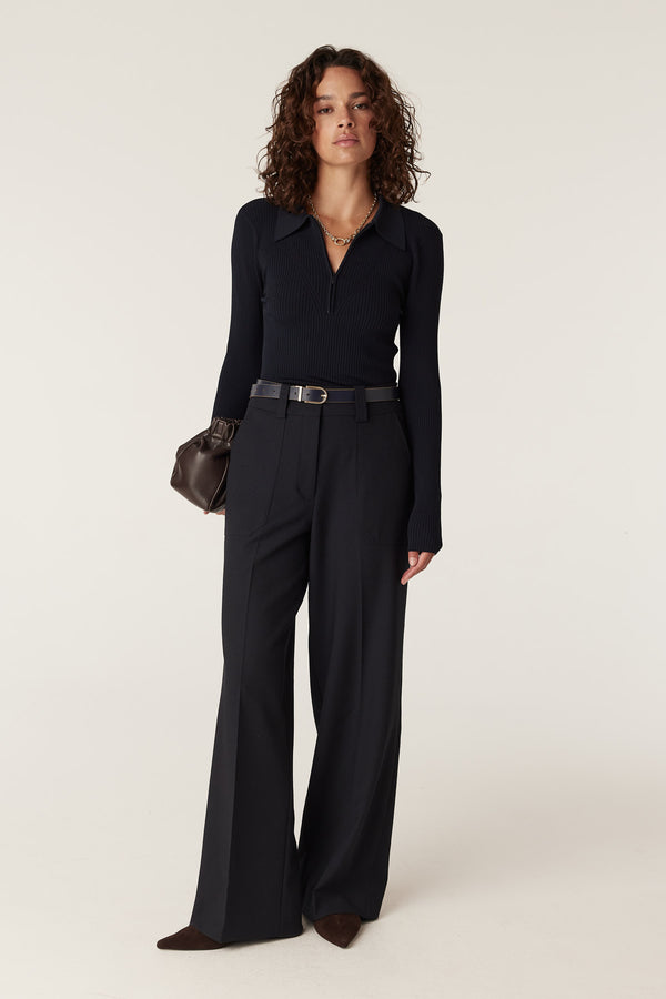 Navy rib knit polo zip top with collar, long sleeves, and vertical ribbing, worn by a model.