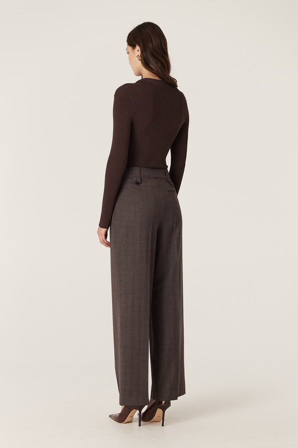 Woman wearing a chocolate brown rib knit polo zip top and dark pinstripe wide-leg trousers.
