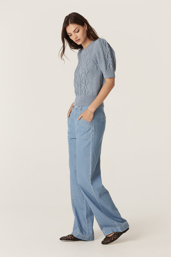Woman wearing a dusty blue Tavi Knit Top with cable stitch, tucks at sleeve head, and rib trims.