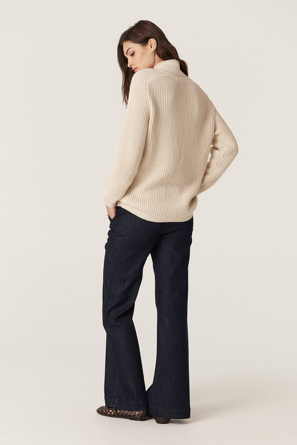 Woman in a relaxed fit oatmeal cotton linen blend fisherman rib knit sweater with a shawl collar.