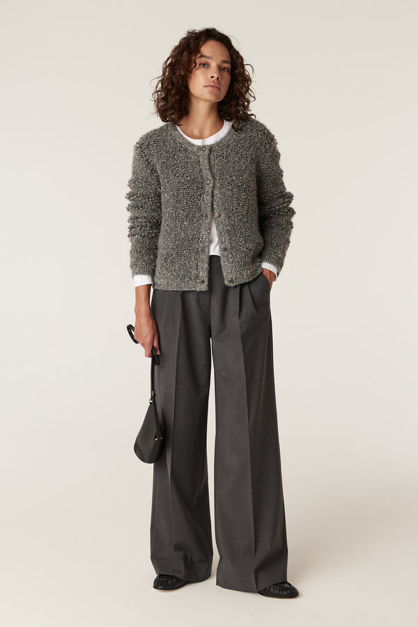Ash grey teddy knit cardigan with buttons, worn by a model over a white tee and wide-leg trousers.