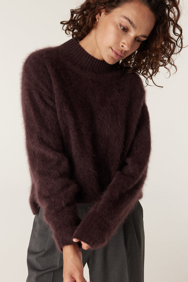 Woman wearing a soft, brushed shiraz cashwool turtle neck jumper with long sleeves.