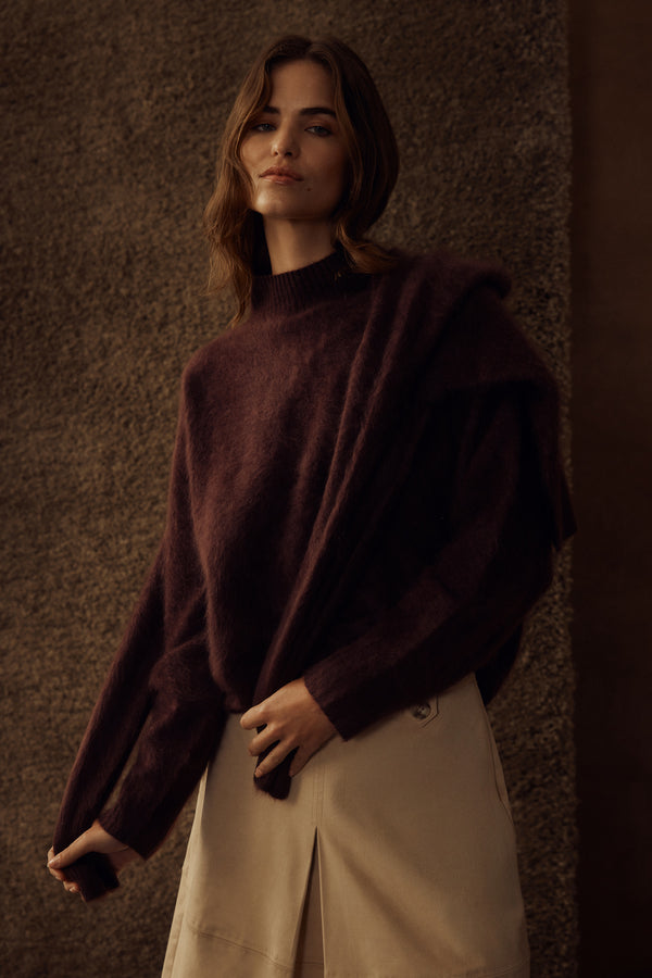 Woman wearing a cozy, brushed Shiraz cashwool turtle neck jumper and beige skirt.