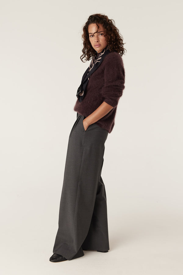 Woman wearing a shiraz brushed cashwool turtle jumper with wide-leg grey trousers and a silk scarf.