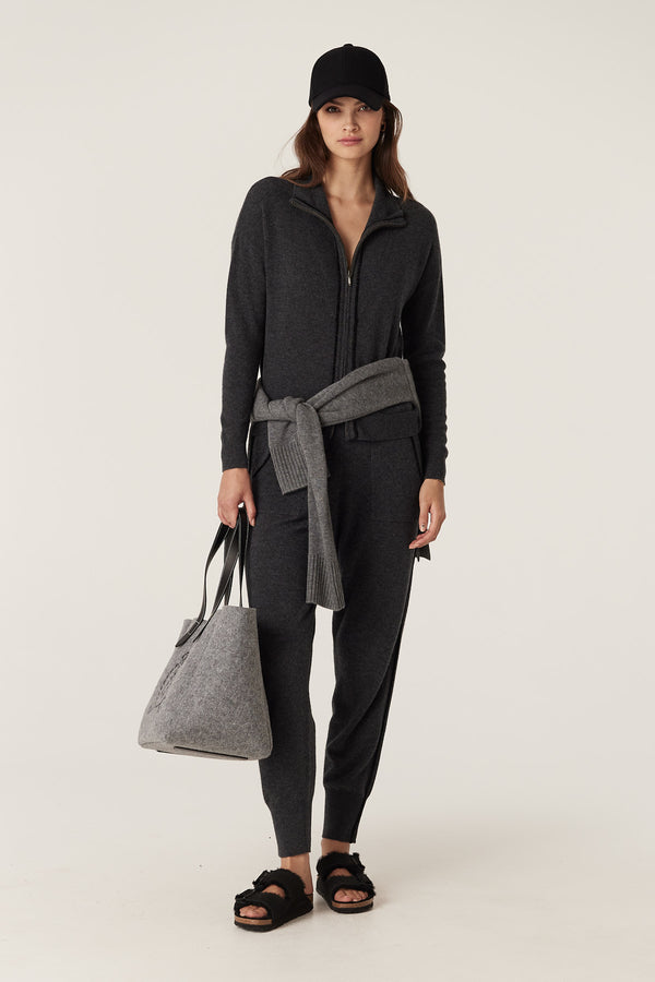 Woman in charcoal Cashwool track zip jumper, matching pants, and a grey felt tote bag.