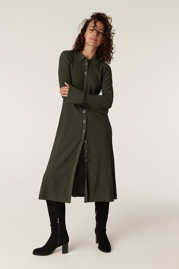 Woman in a ribbed khaki green crepe midi dress with a collar, long sleeves, and front buttons.