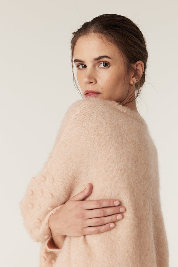 Woman in a nude mohair blend bobble jumper with balloon sleeves and a crew neckline.