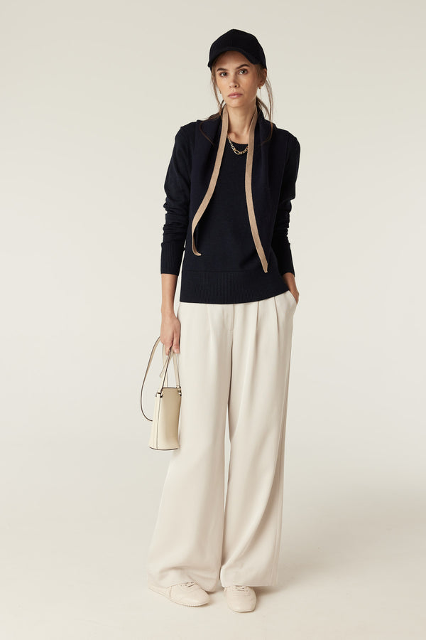 Navy Cashwool neck scarf draped over a woman's shoulders, paired with a navy sweater.