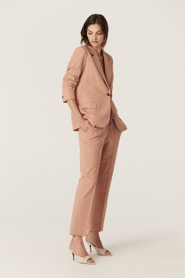 Woman in a clay Owen Blazer and matching pants, featuring a single button closure and revere collar.