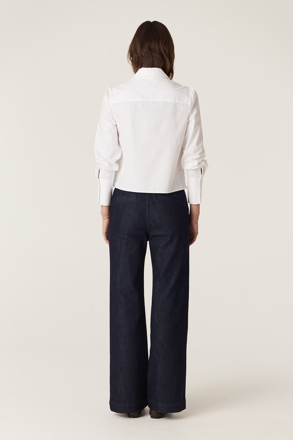 Back view of a model wearing the white May Shirt, a regular fit 100% crisp cotton shirt with structured cuffs.