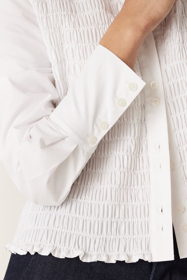 White 100% cotton May Shirt with shirred front, button-through closure, and structured cuffs.