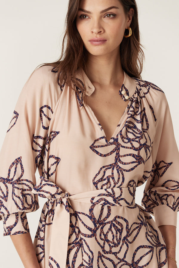 Bloom Dress: Pink silk blend with dark blue stencil floral print, stand collar, button detail, and waist tie.