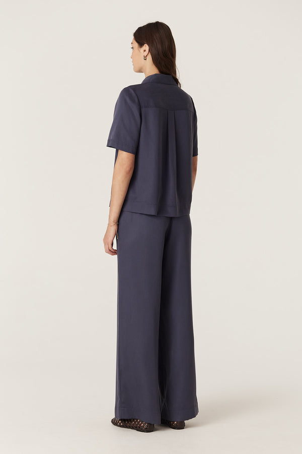 Woman from behind wearing a navy Lyocell Ashton Blouse and matching wide-leg pants.