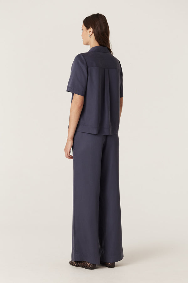 Woman in navy lyocell Ashton Pant and matching blouse, showing relaxed fit and elasticated waist.