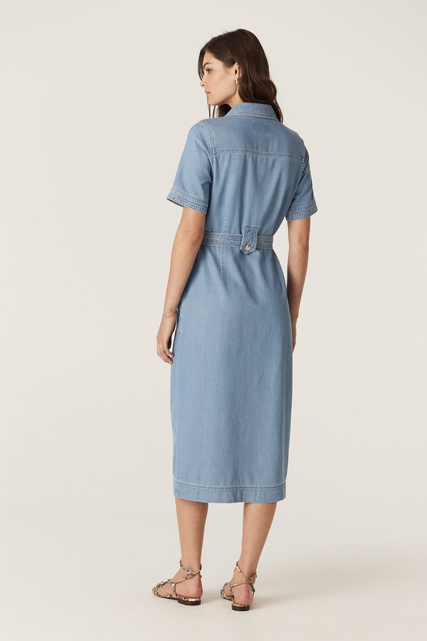 Woman in a blue lyocell cotton blend Pearce dress with short sleeves, button front, waist tie, and contrast stitching.