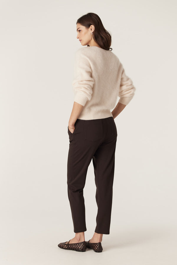 Woman wearing dark espresso Luca twill joggers with back patch pockets and a cream sweater.