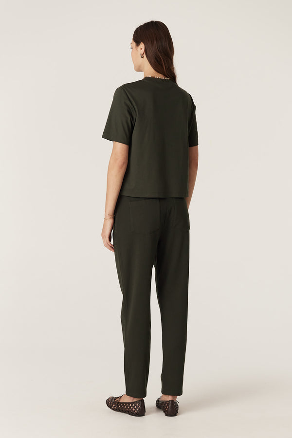 Woman wearing forest green Luca Twill Joggers with back patch pockets and a matching top.