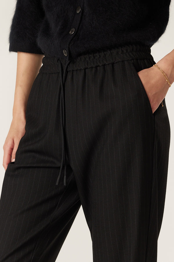 Black pinstripe wool blend Vincent pants with elasticated drawcord waist and functional front pockets.