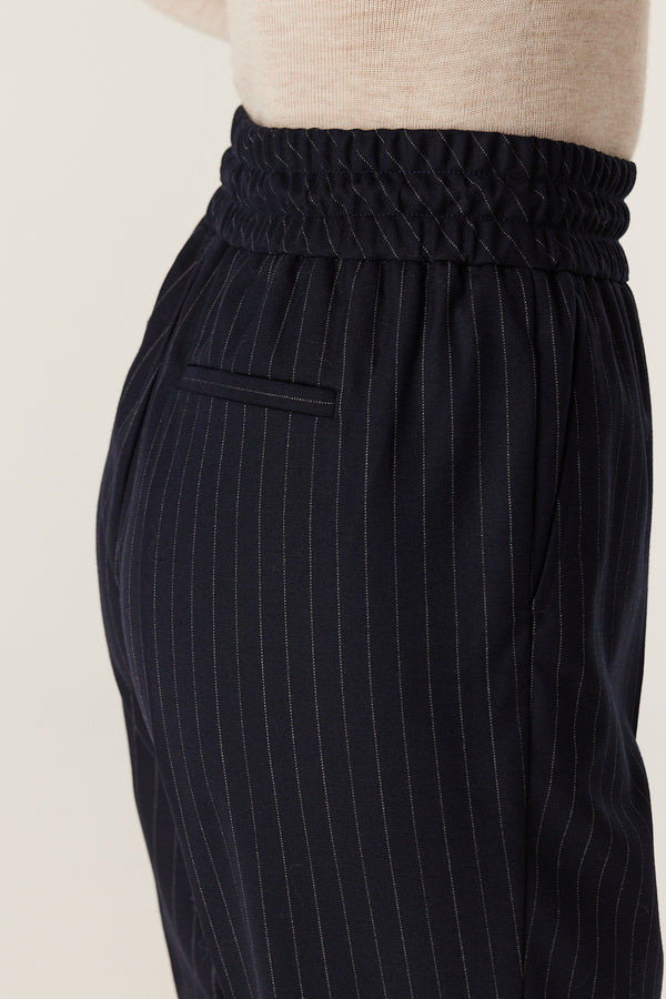Navy pinstripe wool blend Vincent pant with elasticated waist, drawcord, and mock back pocket.