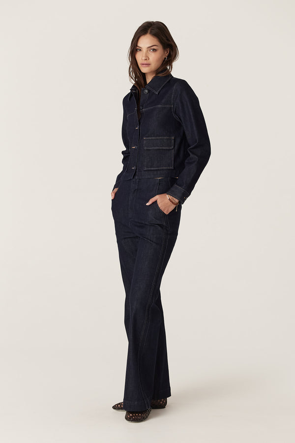 Woman wearing a dark indigo Burke denim jacket with front pockets and matching jeans.