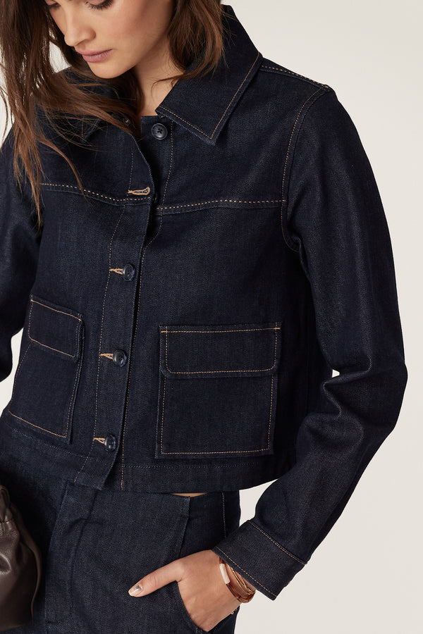 Dark indigo denim jacket with contrast stitching, front pockets, and button-through front.