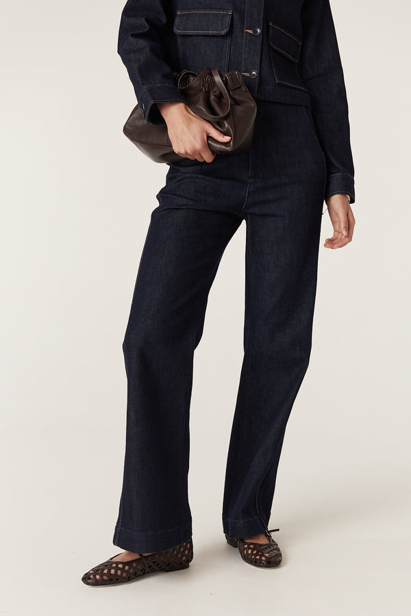 Dark indigo Burke jeans with subtle flared leg, pick stitching, and matching jacket.
