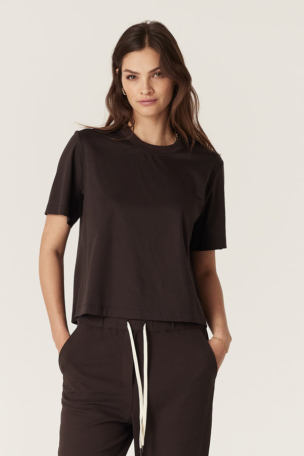 Woman wearing a relaxed fit Pima Boxy Tee in Espresso with matching pants and white drawstring.