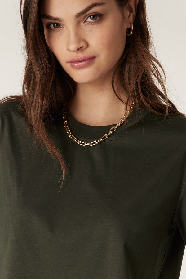 Woman wearing a relaxed fit forest green Pima cotton boxy tee with a ribbed crew neck and short sleeves.