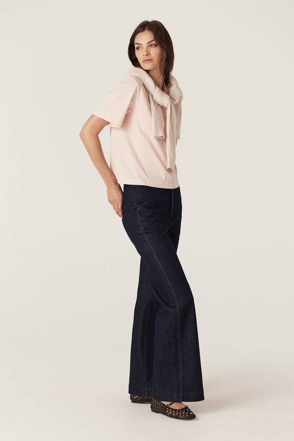 Model wears a blush Pima Boxy Tee with a relaxed fit, crew neck, and short sleeves, paired with dark jeans.