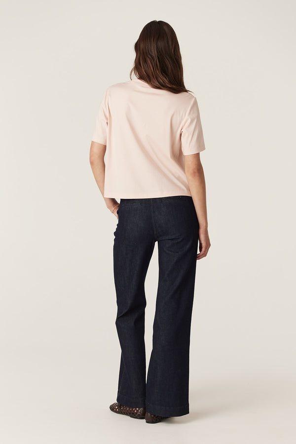 Woman wearing a relaxed fit blush Pima Boxy Tee with short sleeves and dark jeans.