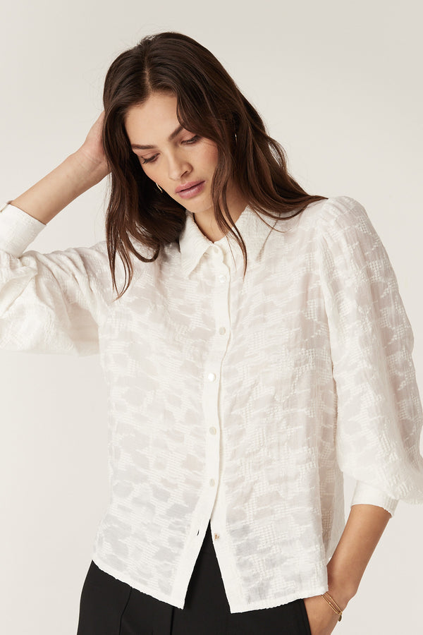 Model wearing an ecru Vella Jacquard Blouse with soft sleeve gathers, button cuffs, and shell buttons.