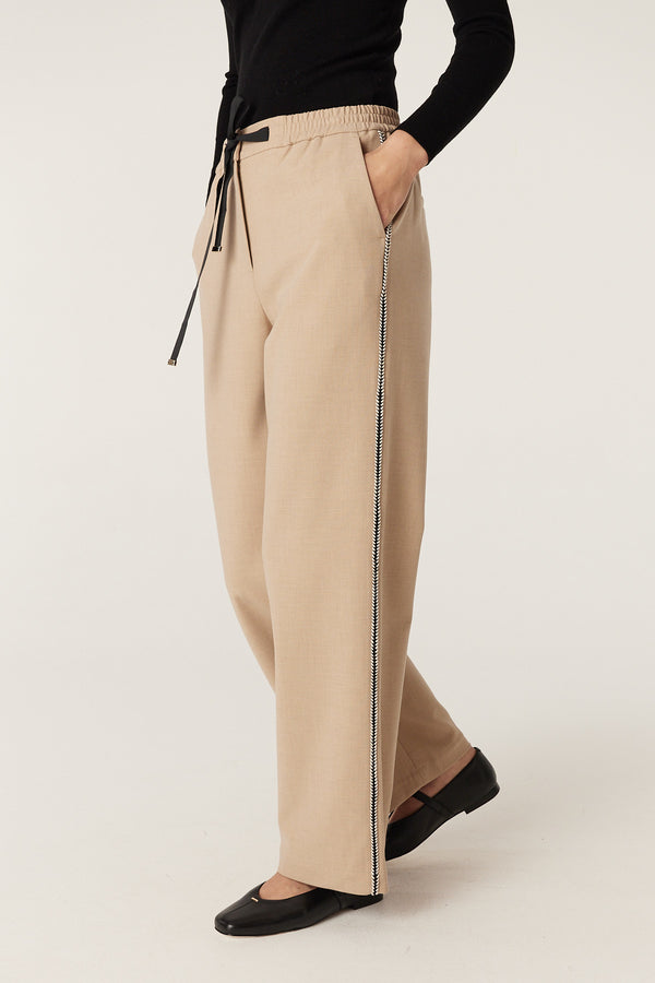 Camel Row Pant with elasticated waist, black tie, side pockets, and contrast braid trim.