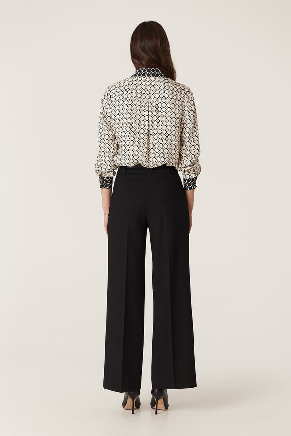 Hamilton Blouse in ivory geo print silk blend, worn with black wide-leg pants, viewed from the back.