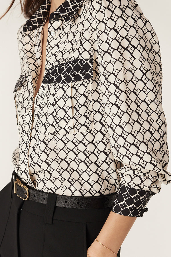 Ivory geo print silk blend blouse with black contrast details, patch pockets, and buttoned cuffs.