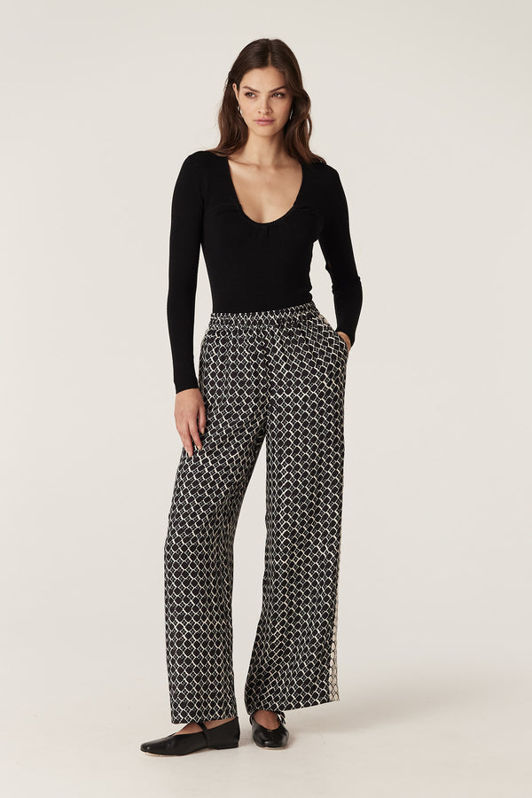 Woman in black geo print Hamilton wide-leg silk blend pants with side pockets and contrast panel.