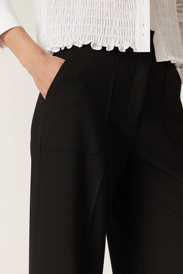 Black Evie wide leg pants with a high waistband and front patch pockets, worn with a white top.