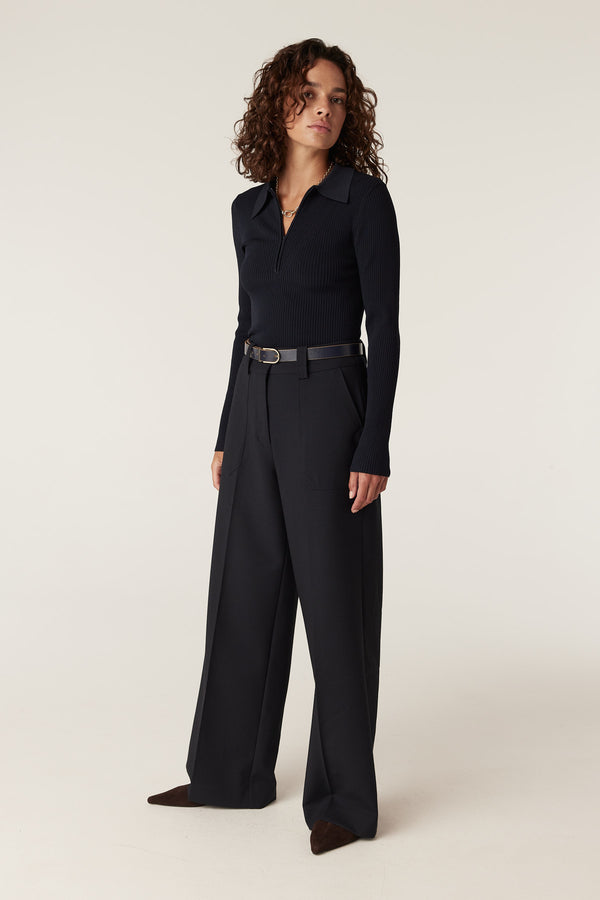 Woman in navy Evie wide leg pants with front patch pockets, high waist, and a dark belt.