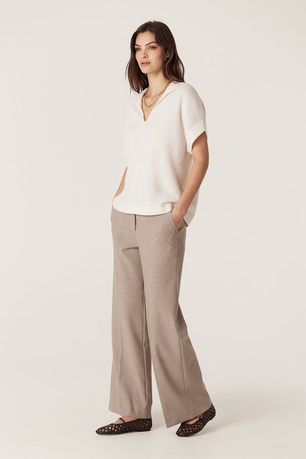 Model wearing fawn Evie wide leg pants with a high waistband, front patch pockets, and a cream top.