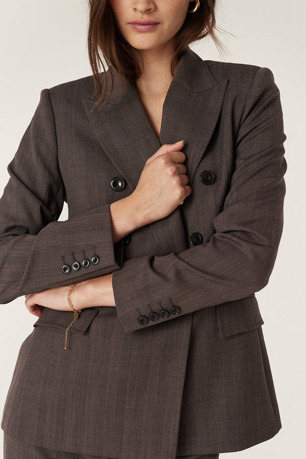 Mocha double-breasted wool blend blazer with revere collar, pick stitch detail, and cuff buttons.