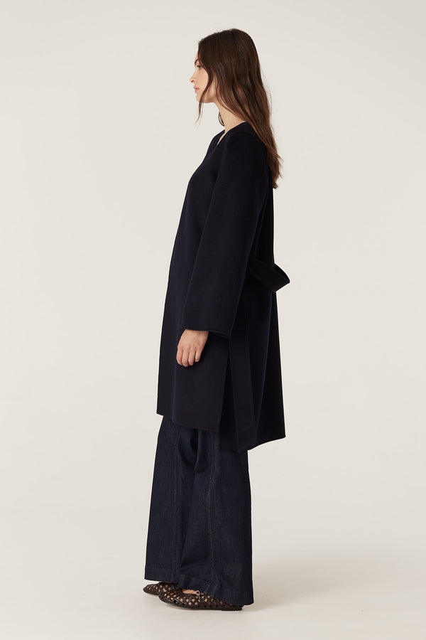 Model wears a navy Lawson wool coat with a relaxed fit, flared sleeves, and a matching belt.