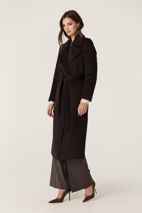 Woman wearing an Espresso Evans tailored wool coat with a wrap closure and fabric belt.