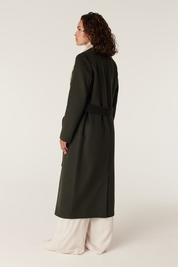 Model wearing a forest green Evans tailored wool coat with a wrap closure and fabric belt.